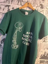 Remera verde con estampado de Calamardo de Bob Esponja y el logo de Anti Social Social Club en blanco.