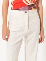 Pantalón de lanilla color crudo con finas rayas verticales de lurex, corte flare y cintura sastrera.