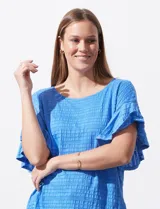 Blusa de mujer color azul vibrante con textura acanalada y pequeños patrones jacquard en relieve. Presenta un escote redondo y mangas cortas con vuelo.
