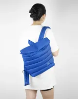 Mochila acolchada color beige con cierre superior enrollable y hebilla.