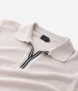 Polo de manga corta con textura en relieve, cuello tipo polo con abertura frontal sin botones y detalles de líneas contrastantes en cuello y puños.