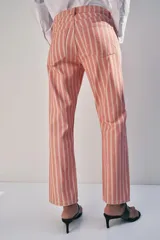 Jeans de tiro medio con diseño de rayas verticales a contraste. Cuenta con cinco bolsillos, trabillas en la cintura y cierre frontal con cremallera y botón.