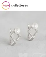 Aros tipo argolla con diseño geométrico en forma de rombo, engastados con pequeñas circonias brillantes y rematados con una perla blanca. Fabricados en plata 925.