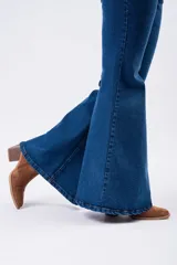 Pantalón de jean estilo Oxford de tiro alto, con ajuste en muslos y corte acampanado en la parte inferior. Presenta un lavado azul clásico y costuras reforzadas.