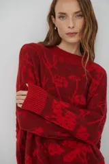 Buzo de tejido de punto con cuello redondo, mangas largas con puños acanalados y diseño estampado de flores en tonos rojos.