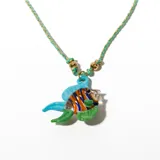 Collar con dije de pez de vidrio multicolor, con detalles en azul, naranja y verde. Cordón trenzado color verde agua con detalles dorados y cuentas doradas.