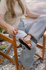 Sandalias planas de cuero con tiras finas que se atan alrededor del tobillo y la pierna. Diseño minimalista con suela flexible y ligera.