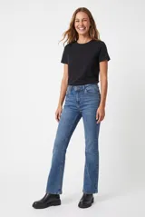 Jean flare negro de tiro alto, confeccionado en denim con bolsillos clásicos y cierre frontal de botón y cremallera.