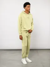 Pantalón jogger de felpa sin frisa, color gris claro melange, con logo bordado de Umbro en azul oscuro en el muslo izquierdo y puños elásticos en los tobillos.