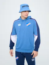 Canguro deportivo Umbro del Club Nacional de Football, modelo Nexo para hombre. Diseño en color azul marino con mangas rojas y detalles en celeste y blanco, capucha con cordón ajustable y bolsillo tipo canguro.