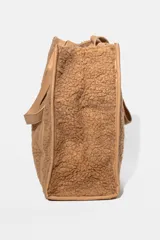 Cartera tipo tote de textura de peluche en color verde oliva, con manijas y detalles de refuerzo en cuero sintético al tono.