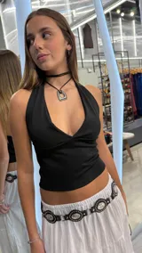 Top negro de tejido rib con escote halter pronunciado.