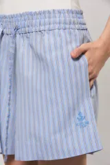 Short de calce regular confeccionado en tejido camisero, con estampado de rayas verticales en tonos celestes, azules y blancos. Cuenta con cintura elástica fruncida y cordón ajustable del mismo material.