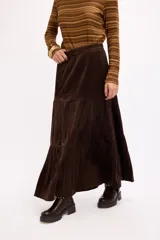 Falda larga de corte acampanado con diseño de paneles horizontales y textura símil terciopelo.