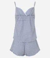 Pijama short doll de dos piezas confeccionado en algodón, con estampa de cuadros vichy en tonos azul y blanco. La musculosa presenta breteles finos, escote corazón con delicado encaje blanco y silueta fluida. El short cuenta con cintura elástica, pequeño moño frontal y terminación ondulada en el ruedo.