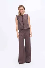Pantalón de pierna amplia y tiro alto, confeccionado en tejido a rayas con una mezcla de algodón, poliéster y lino. Presenta un diseño de corte sastrero con bolsillos laterales y trabillas para cinturón.