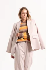 Blazer sastrero de corte recto y estructura clásica, confeccionado en tela tipo gabardina. Presenta solapas tradicionales, hombreras marcadas y bolsillos laterales con solapa.