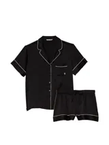Pijama corto de satén negro con estampado monograma sutil, ribetes blancos y diseño de botones frontales.