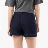 Short de jean azul oscuro, de tiro alto, con detalles trenzados en los bolsillos delanteros y vuelta en el ruedo.