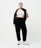 Pantalón jogger de plush color negro, con cintura elástica, bolsillos laterales y puños ajustados en los tobillos.