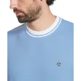 Remera celeste de piqué con cuello redondo y mangas cortas con ribete blanco. Presenta un pequeño logo bordado de un pingüino en el pecho.
