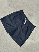 Short de baño negro con estampado geométrico y cordón blanco en la cintura.