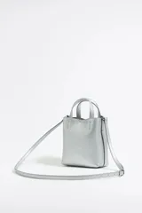 Bolso de mano mini color plateado, con doble asa corta y correa larga extraíble.