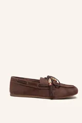 Mocasín estilo náutico de gamuza marrón, con cordones de cuero, borla decorativa y cuentas de colores en el empeine.