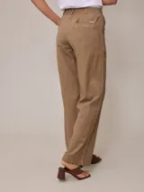 Pantalón de lino color tostado, de corte recto y tiro alto, con trabillas para cinto y bolsillos laterales.