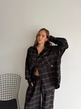 Pantalón de corte recto y holgado, confeccionado en tela de viyela con estampado de cuadros en tonos negro, gris y blanco. Presenta cintura elástica para mayor comodidad.