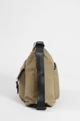 Mochila hobo color marrón claro, convertible en cartera de hombro, confeccionada en nylon. Cuenta con un compartimento principal con cierre, un bolsillo frontal con solapa y cierre de botón a presión, tiras regulables negras y un llavero colgante decorativo con cuentas coloridas y borla.