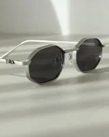 Lentes de sol plateados con forma octogonal y lentes negras.