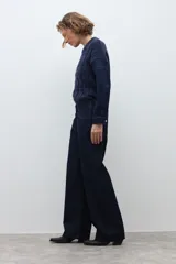 Pantalón de jean de corte wide leg en color azul oscuro, con tiro medio y cierre frontal con botón y cremallera.