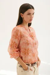 Camisa color coral con estampado floral, cuello mao y mangas 3/4 con volados.