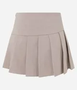 Short pollera de tiro alto en color beige, con diseño de sastrería, tablas delanteras y ruedo asimétrico.