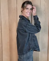 Sobrecamisa de denim con diseño de rayas verticales, corte holgado, cuello camisero, cierre frontal con botones y bolsillos delanteros aplicados.