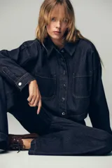 Pantalón de jean de tiro alto con corte de pierna ancha, cintura elástica con cordón ajustable y bolsillos laterales.
