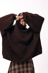 Sweater de punto grueso color chocolate, con cuello alto y mangas amplias de diseño holgado.