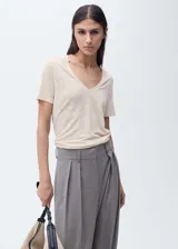 Camiseta de lino color beige, de corte recto, con mangas cortas y escote en V.