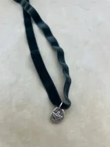 Gargantilla de terciopelo con dije plateado con forma de paloma.