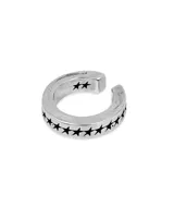 Earcuff de plata con diseño abierto y grabado de estrellas negras en todo el contorno.