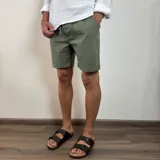 Bermuda de corte recto en color beige, confeccionada en tejido simil lino. Presenta cintura elástica con cordón de ajuste y bolsillos laterales.