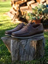 Zapato náutico de cuero vacuno con textura granulada, cordones al tono y suela de goma gris. Presenta costuras reforzadas en la puntera y diseño clásico con ojales metálicos.