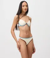 Bombacha de bikini básica confeccionada en microfibra texturizada color blanco marfil, con doble hilo y ribetes en contraste en tono marrón y celeste.