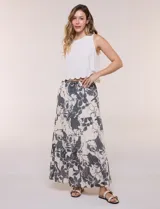 Falda maxi color crudo con estampado floral en tonos oscuros, tiro alto con cintura elástica fruncida, cordón de ajuste frontal y diseño escalonado de tres paneles con vuelo.