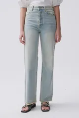 Jean celeste de calce recto, tiro medio-alto, lavado claro y ruedo desflecado.