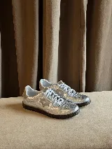 Championes de estilo urbano en color plateado metalizado con acabado texturizado. Presentan cordones blancos, suela de goma oscura y un detalle lateral en forma de estrella. Diseñados con doble plantilla acolchada para mayor comodidad.