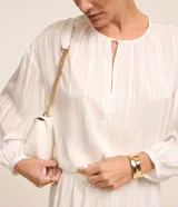 Blusa de manga 3/4 en chiffon de color blanco con rayas metalizadas y cuello redondo con abertura en gota.