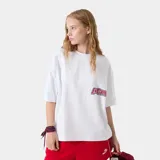 Remera oversized de algodón blanca, de manga corta y cuello redondo, con estampado gráfico multicolor en la espalda.