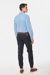 Pantalón cargo azul marino con bolsillos laterales con solapa y cinturón de cuero marrón.